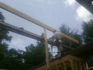 Carpenter setting a ridge beam over a new addition frame — Ice Dam Removal by Roofing Brothers in Wildersville
