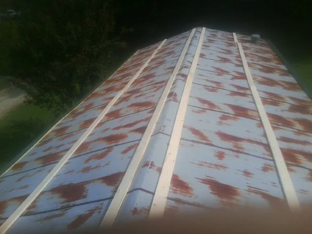 Rusted metal roof panels with new wood purlins before replacement — Storm Damage Roof Repair in Wildersville by Roofing Brothers