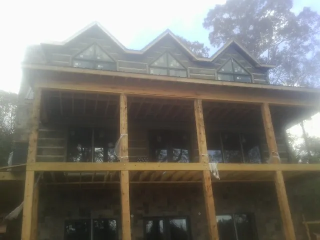 Dormers and porch framing on a large log home under construction in Wildersville