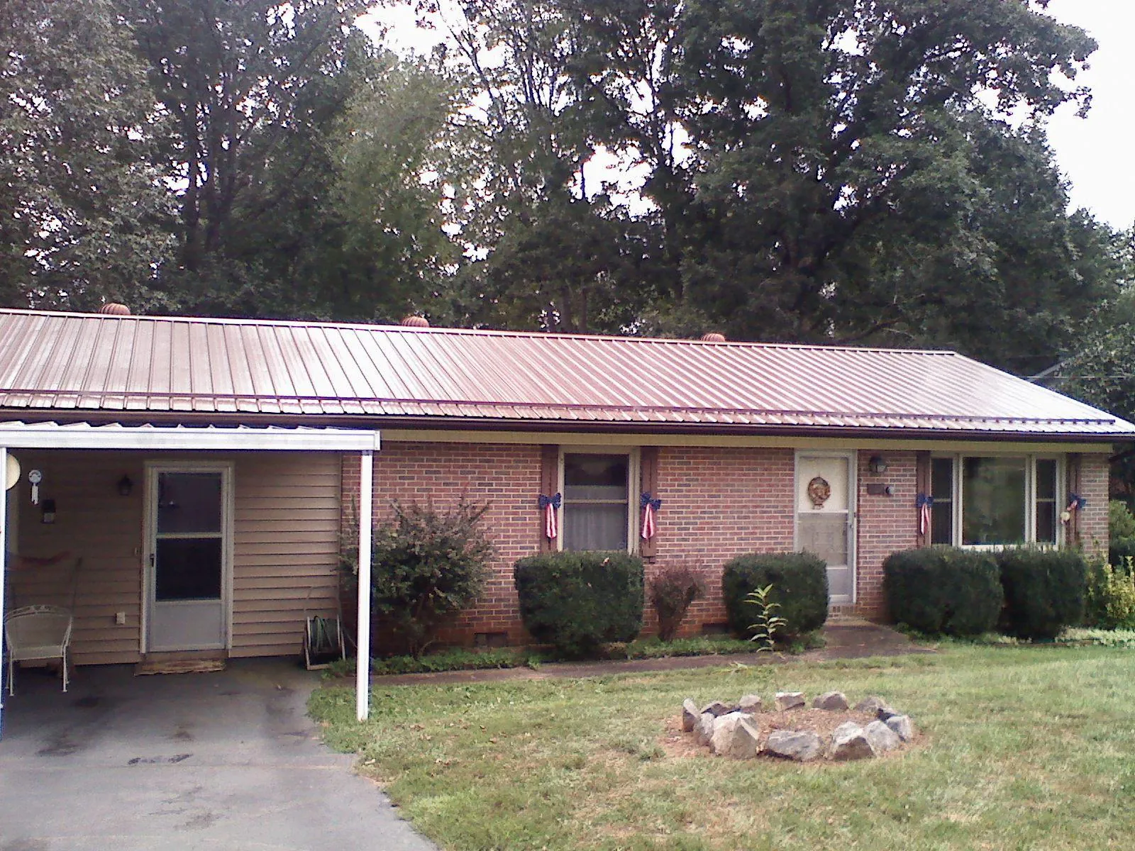 Bronze metal roof and carport on a brick ranch home — Roof Repair work by our crew in Wildersville
